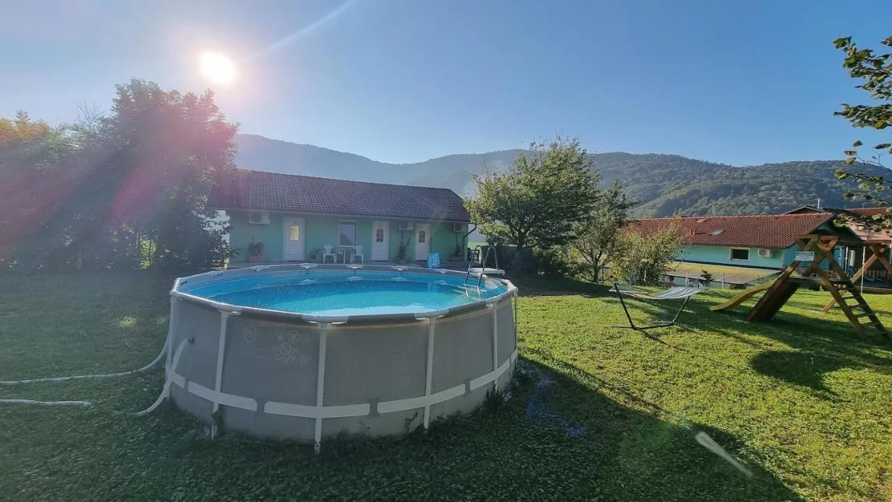 Bazen v večernem soncu pred hišo z apartmaji